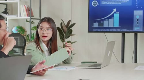 Business Team Meeting Discussing Charts in Modern Office