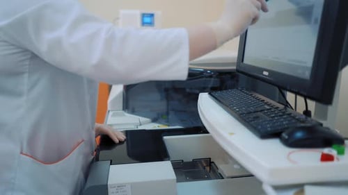 Lab Worker Operating Medical Analysis Equipment