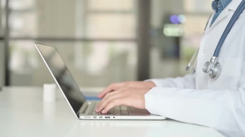 Nahaufnahme eines Arztes, der am Laptop arbeitet