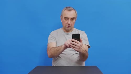 Focused Elderly Man Hold Mobile Learning Digital Technology Surfing Internet. Pensive Grandfather in