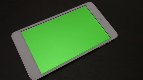 Silver tablet with greenscreen display on wooden surface slow panning 4K 3840X2160 UHD footage - P