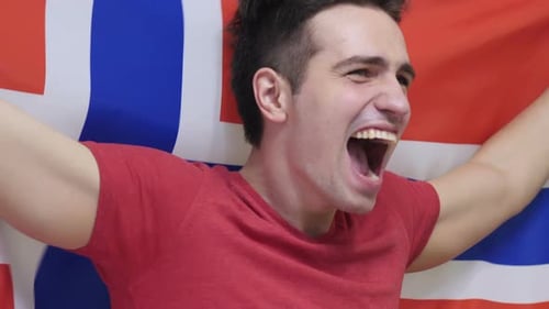 Young Man Cheering with Excitement Holding a Flag