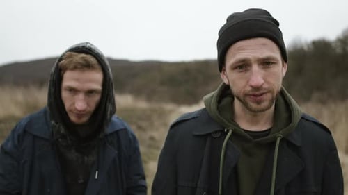 Two Young Guys Standing In Field. Stylish Young Friends.