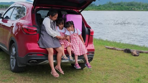 Family Relaxing in Trunk of Car by Lake