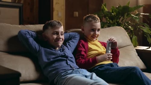 Amigos ou irmãos que descansam no sofá macio em casa e revisando programas na TV