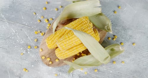 Golden Ears of Corn on Rustic Wooden Board