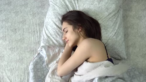 A Young Woman Is Sleeping Under the Covers. A Girl Lies in Bed in His Room. View From Above