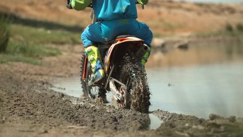 Motocross Bike Splashing Through Muddy Track