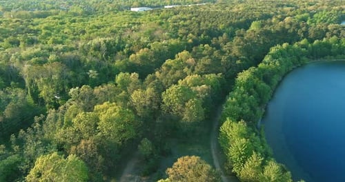 Beautiful spring nature landscape with a blue lake water between green forest