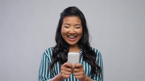 Smiling Woman Using a Mobile Phone
