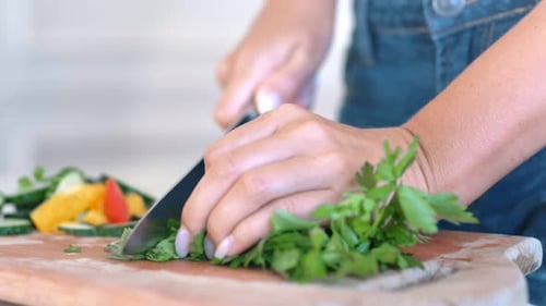 Hands Chopping Fresh Parsley in Bright Kitchen