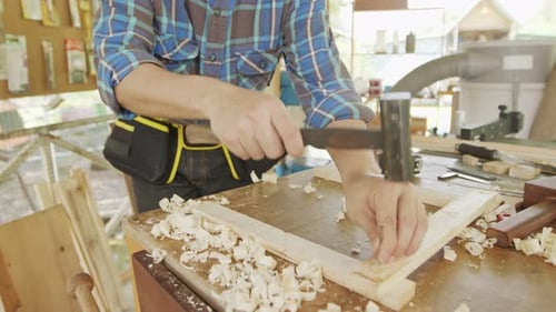 Close up carpenter hammering nails to process furniture