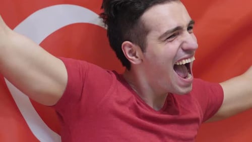 Enthusiastic Man Cheering in Front of Red Flag