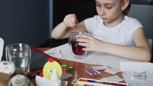 Little Girl Dyes Easter Eggs at Home