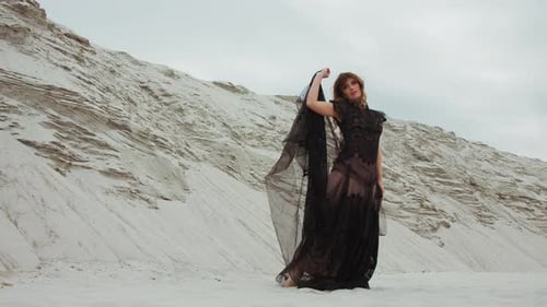 Woman Posing in Elegant Black Dress in Desert