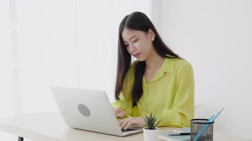 Young asian businesswoman working on laptop computer on desk at home office.