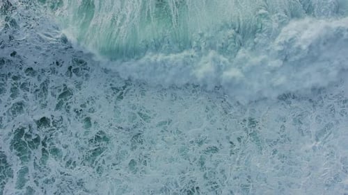 Large Waves on the Surface of the Ocean Overwhelm and Swirl Near the Shore, Aerial View