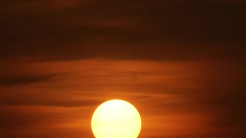 Majestic Sun Setting Through Reddish Orange Clouds