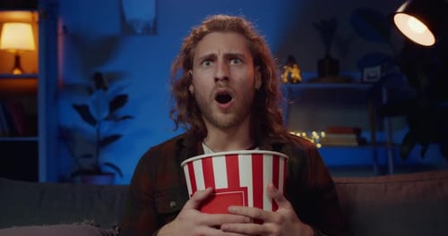 Handsome Hipster Man Making Shocked Facial Expression While Watching Interesting Film. Millennial