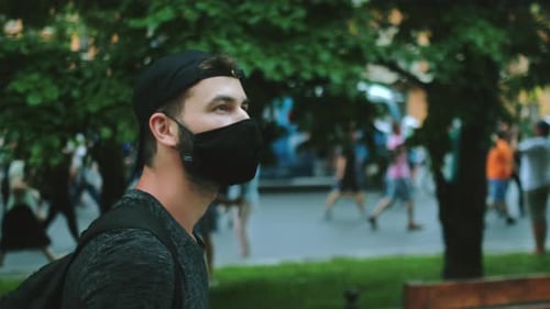 Young Adult Wearing Mask Amongst Crowd in City