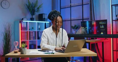 Businesswoman Sitting at Her Workplace in Evening Office and Typing on Computer Keyboard