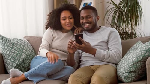 Couple Looking at Phone Together on Couch