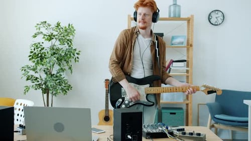 Young Man Playing Electric Guitar at Home
