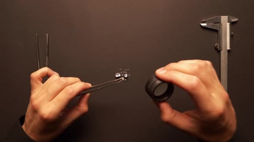 Examining Diamond with Tweezers and Lens, Close Up