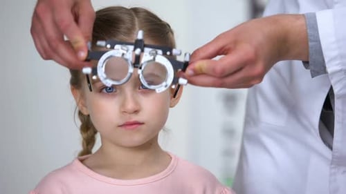 Ophthalmologist Selecting Diopter to Little Girl, Using Optical Equipment