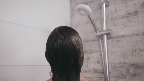 Woman Washing Hair in Bathroom Shower