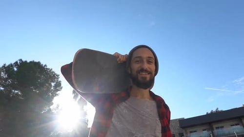 Young Man with Skateboard on Sunny Day