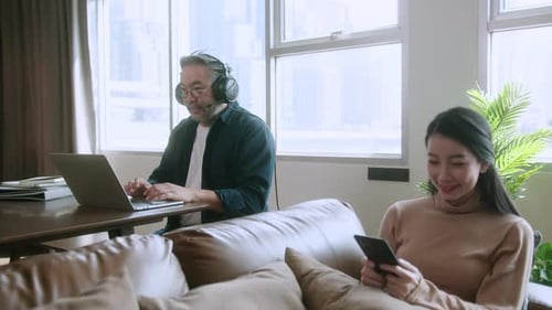 Man Working At Home With Family