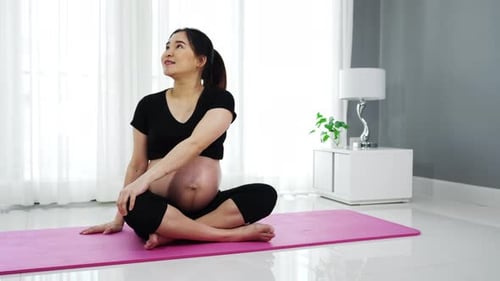 pregnant woman doing yoga exercise in the living room at home