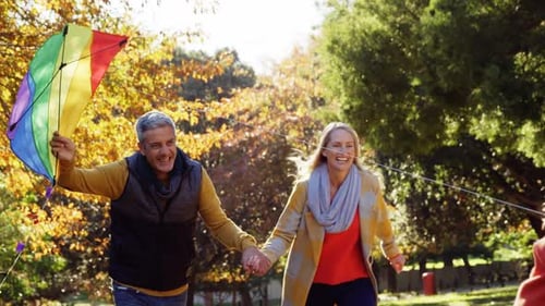 Happy Family Running With Kite in Autumn Park