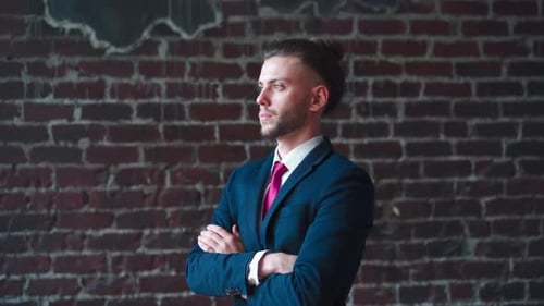 Man in Suit Smiling Against Brick Wall