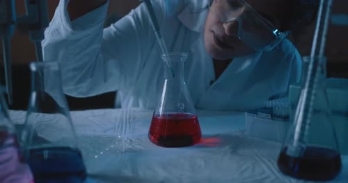 Scientist Working with Flasks and Pipette in Lab