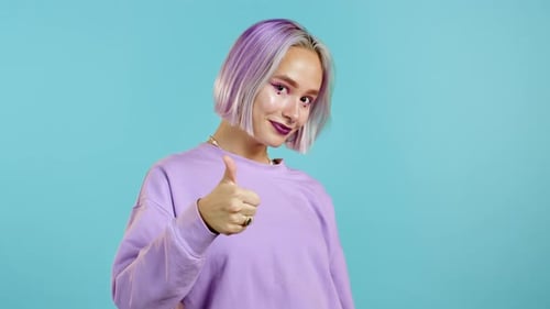 Young Adult with Purple Hair Gives Thumbs Up
