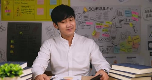 Smiling Young Adult Answers Smartphone in Office