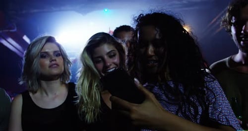 Excited Friends Enjoying Concert Together at Music Venue