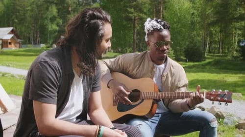 Men Play Guitar Together Outdoors on Sunny Day