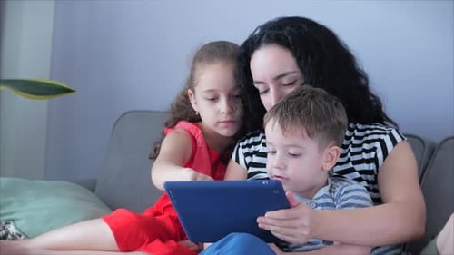 Mother and Children Use Tablet on Couch