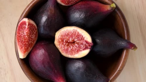 Figs rotating in wooden bowl top view