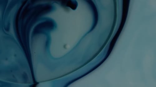 Macro Shot of Mixing Blue and White Liquids