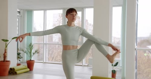 Jeune femme pratique un yoga dans les studios lumineux Utthita Hasta Padangusthasana
