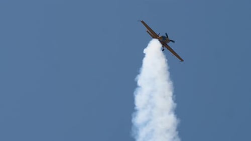 Aerobatic Airplane Performing Stunts in a Blue Sky