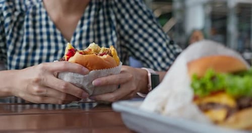 Woman eating burger outside