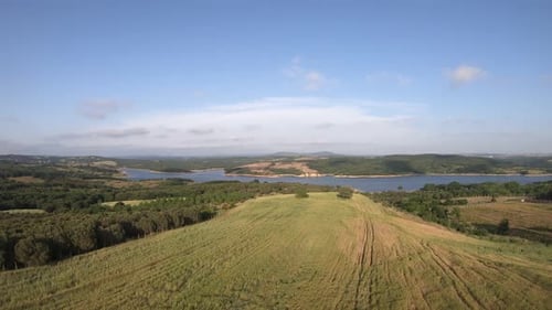Aerial View of Rolling Hills and Serene Lake