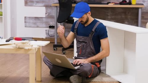 Furniture Assembly Worker Wearing Overalls Searching Instructions
