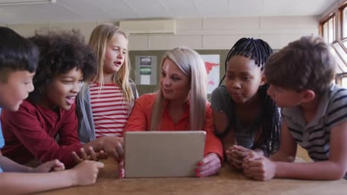 Female teacher and Group of kids using laptop in the class