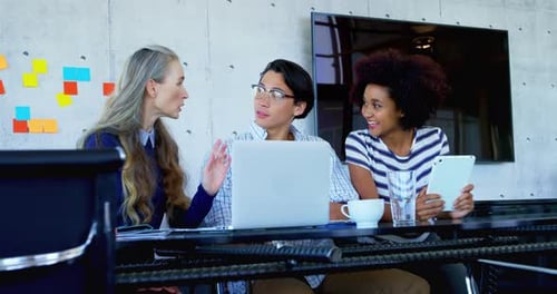 Three Colleagues Discussing Ideas in a Modern Office
